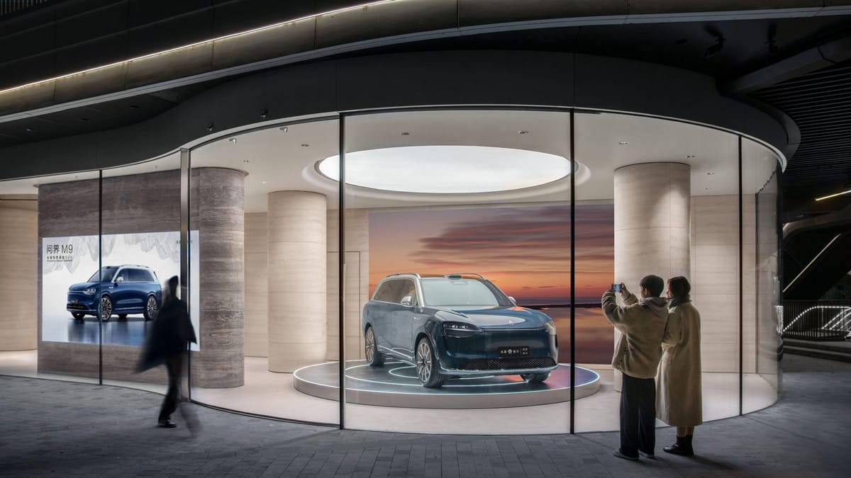 Aito M9 im Schaufenster eines Huawei-Stores in Shanghai, Passanten fotografieren das SUV