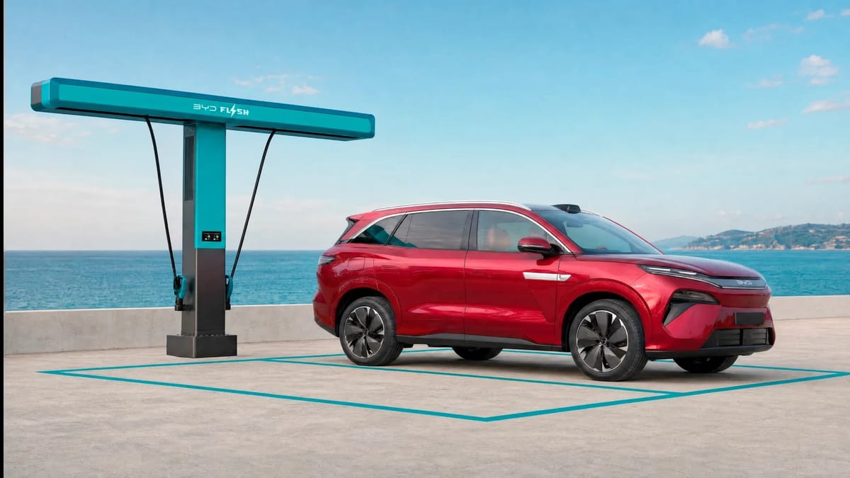 Roter BYD Atto 8 steht an einer türkisfarbenen BYD-Flash-Ladesäule vor Meerkulisse