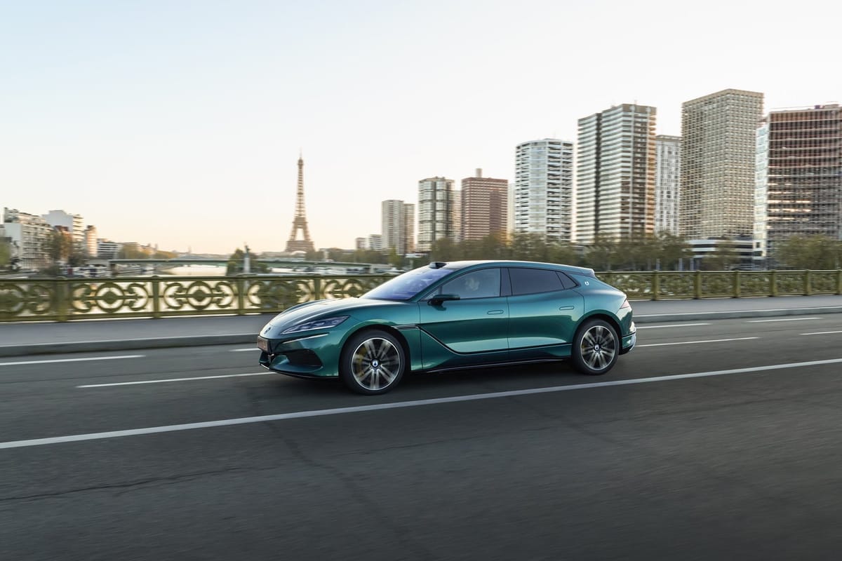 Grüner Denza Z9 GT fährt über eine Brücke in Paris, im Hintergrund der Eiffelturm