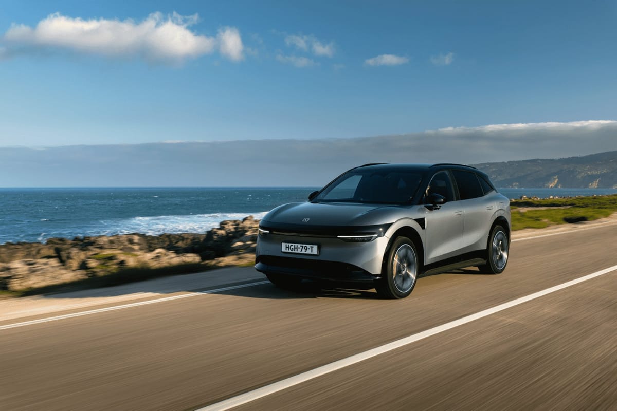 Silbernes Zeekr 7X SUV fährt auf einer Küstenstraße am Meer entlang