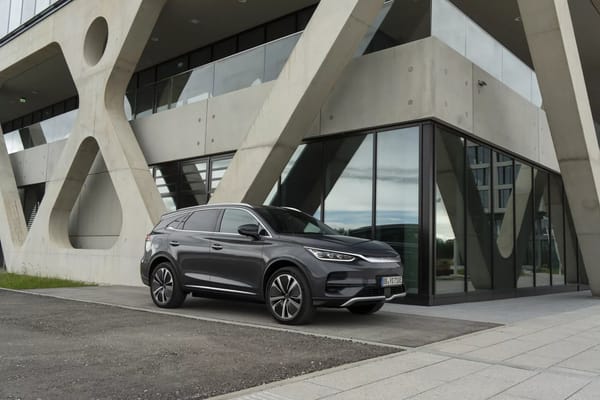 Grauer BYD Tang steht vor einem modernen Betongebäude