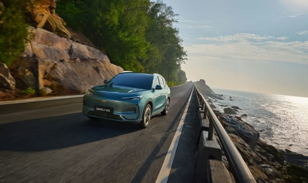 Ein Geely E5 in Mintgrün fährt auf einer Küstenstraße