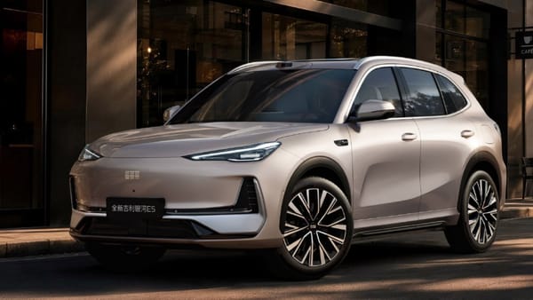 Die Neuauflage des Geely E5 in Champagner steht vor einem Café, auf dem Dach sitzt ein LiDAR-Sensor