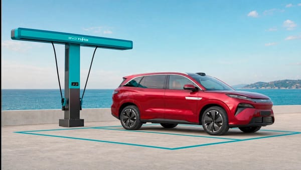 Roter BYD Atto 8 steht an einer türkisfarbenen BYD-Flash-Ladesäule vor Meerkulisse