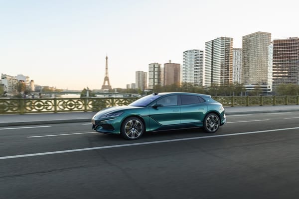 Grüner Denza Z9 GT fährt über eine Brücke in Paris, im Hintergrund der Eiffelturm